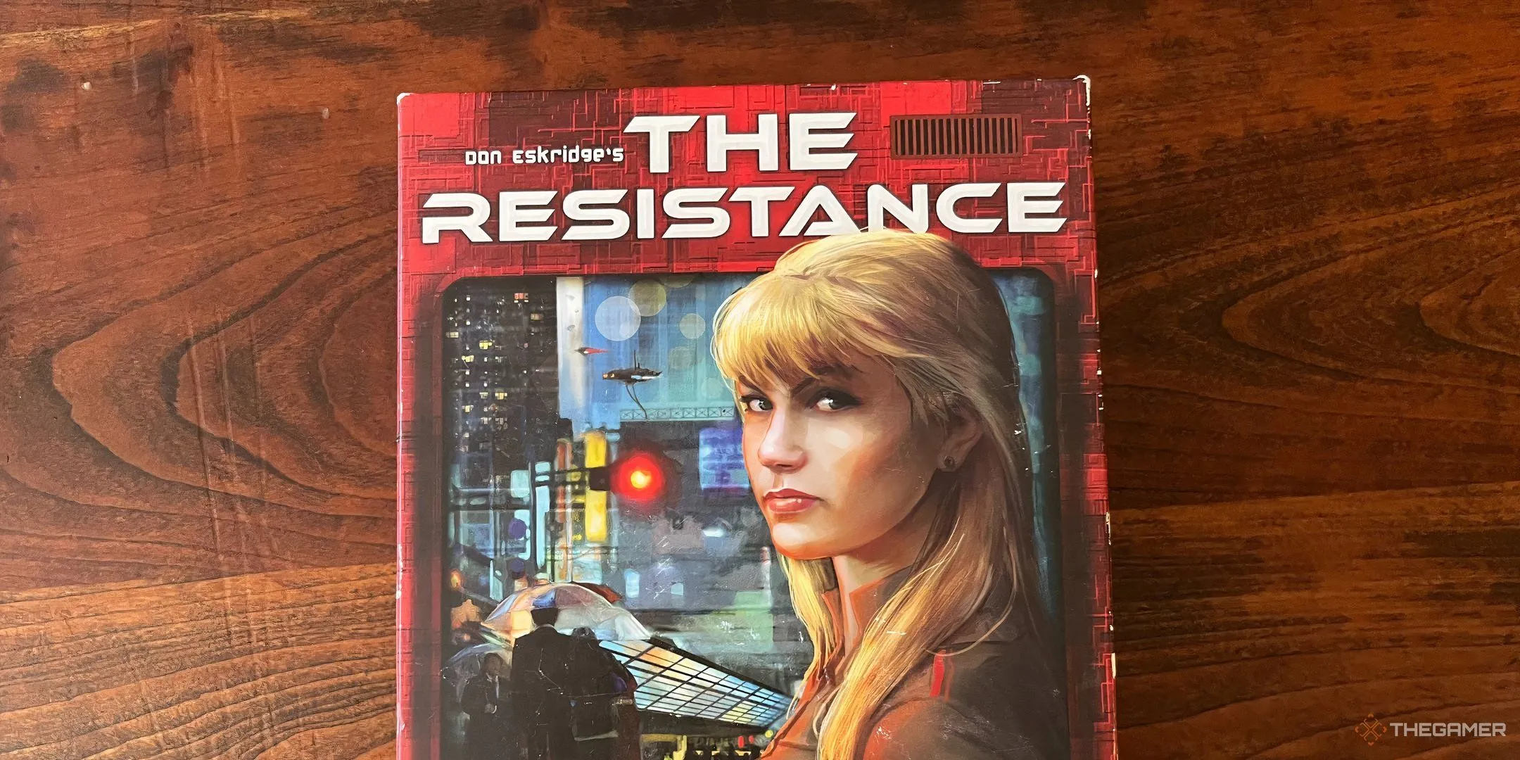 Bìa game The Resistance với hình ảnh nữ điệp viên tóc vàng bí ẩn, gợi không khí phản gián và đối đầu.