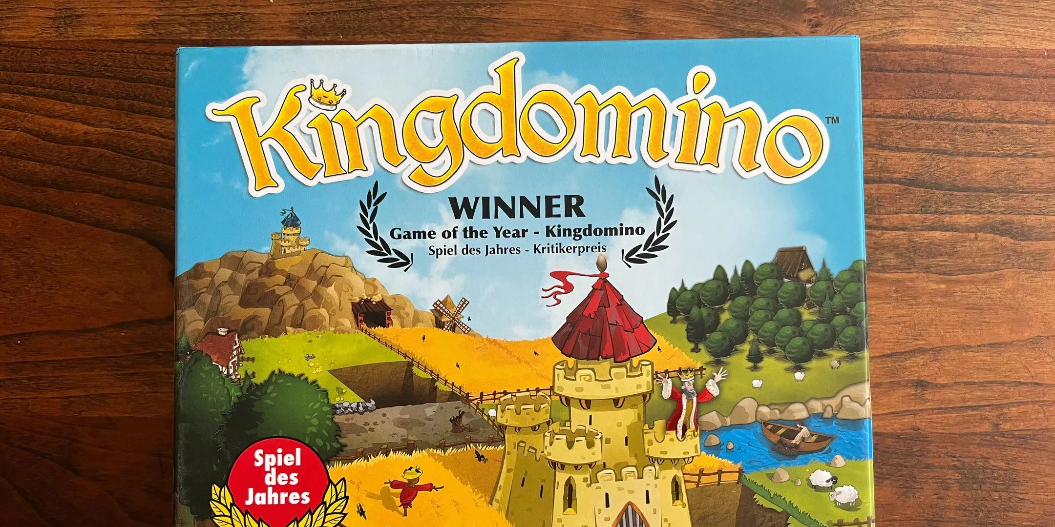 Bìa hộp của board game King Domino, với các ô domino hình vương quốc.