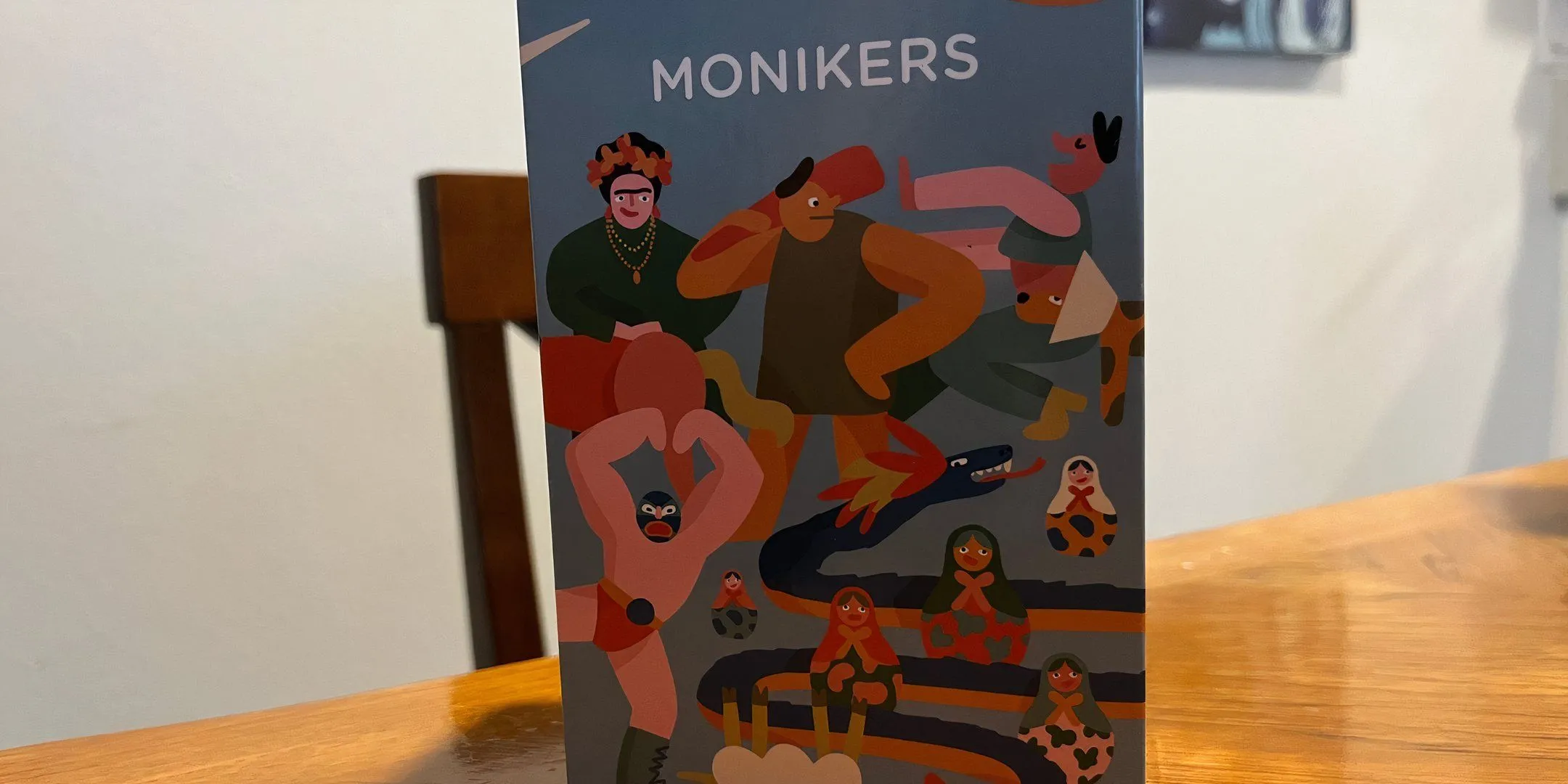 Bìa hộp game Monikers với thiết kế đơn giản nhưng gợi hình ảnh về trò chơi đoán từ, phù hợp cho tiệc tùng.