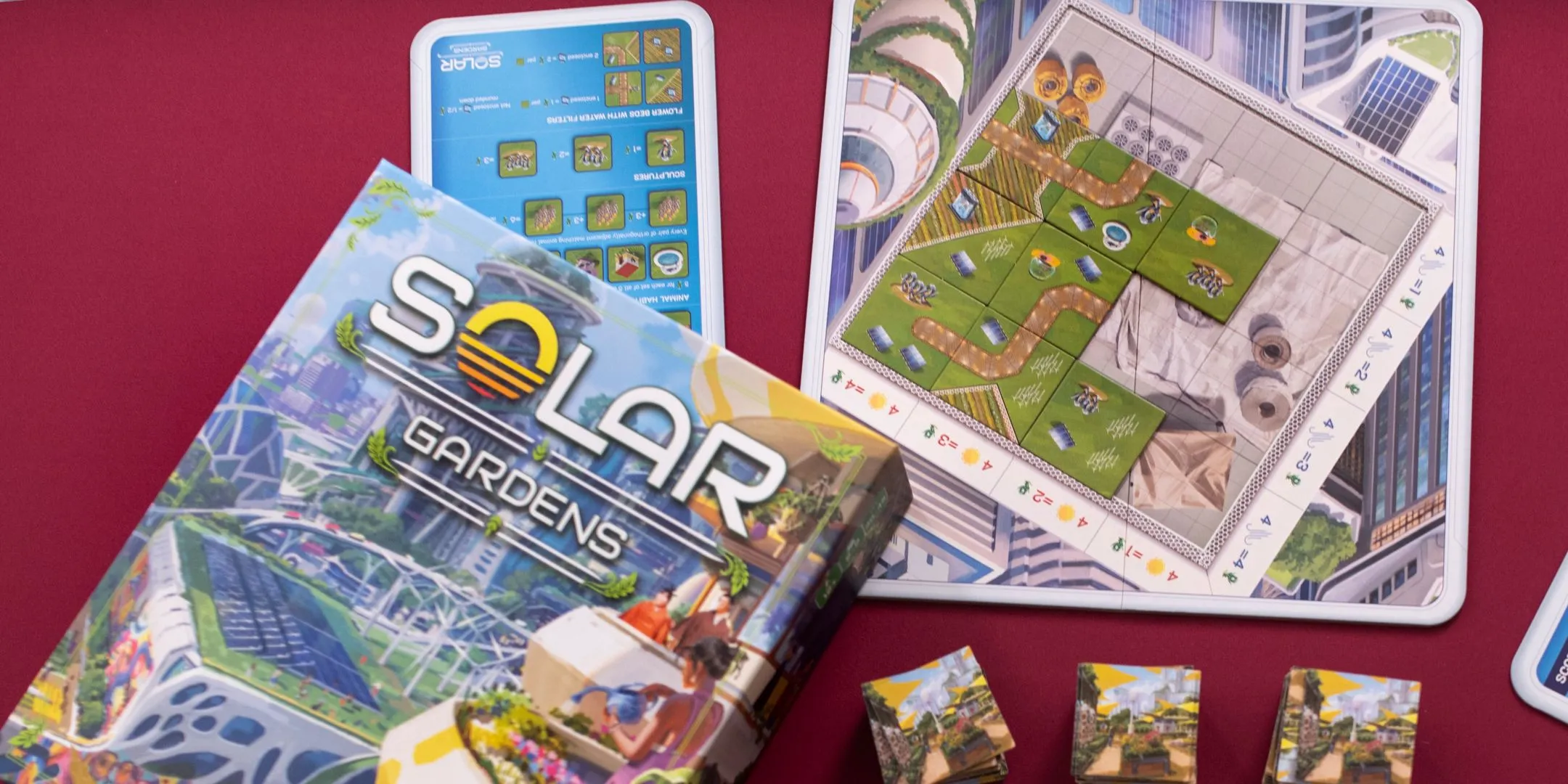 Bộ phận và bảng chơi của board game Solar Gardens được sắp xếp trên nền đỏ, thể hiện sự tinh tế trong thiết kế