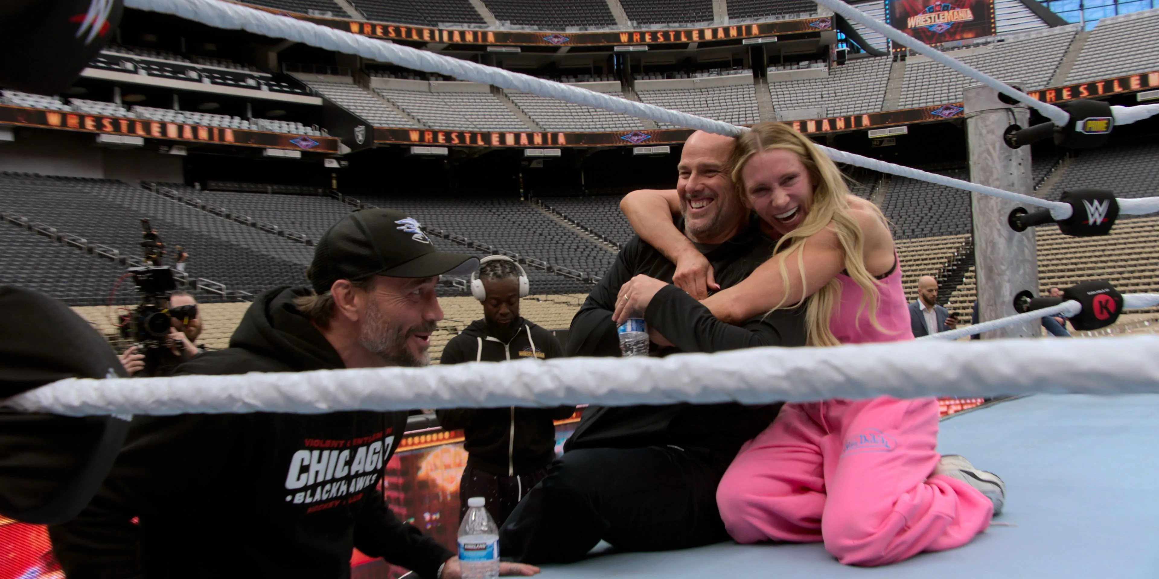 Khoảnh khắc đời thường của CM Punk, Adam Pearce và Charlotte Flair trong WWE Unreal, minh họa sự gắn kết và thoải mái của các đô vật.