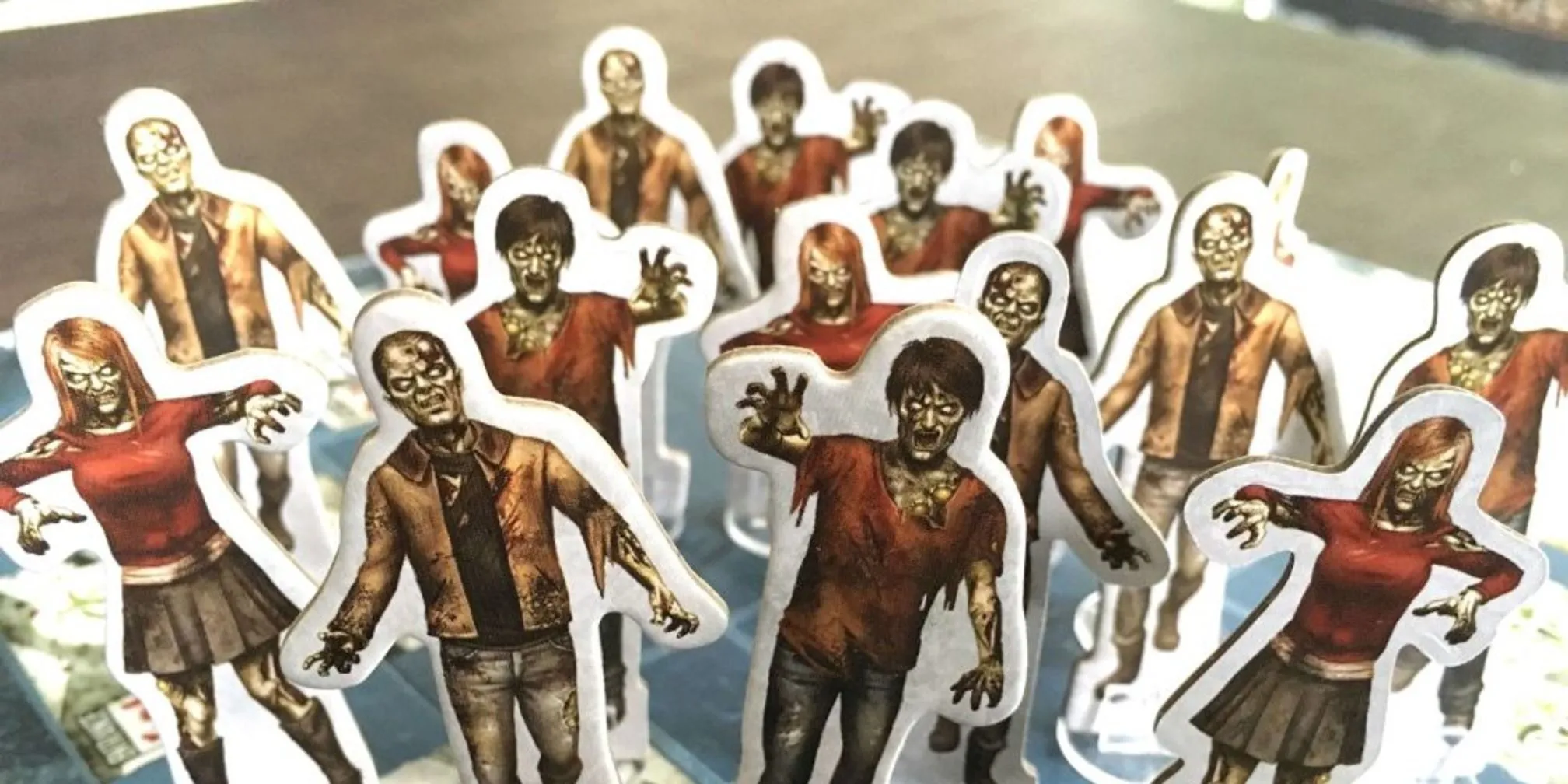 Token zombie và thiết kế hộp game Dead of Winter, thể hiện không khí sinh tồn hậu tận thế.